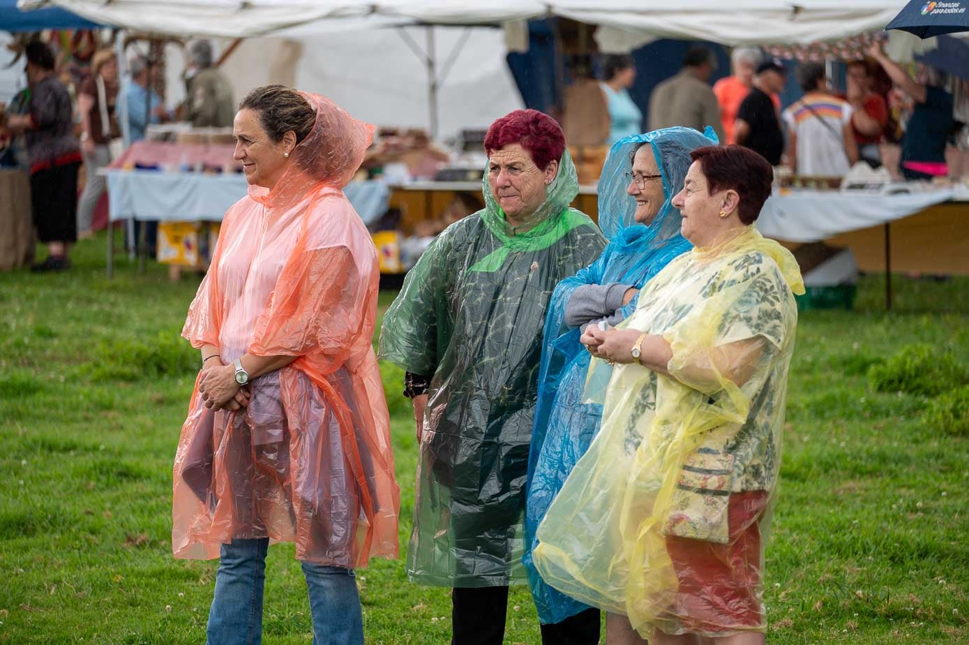 Cuatro mujeres precavidas acudieron a la fiesta, pasada por agua, con chubasquero.