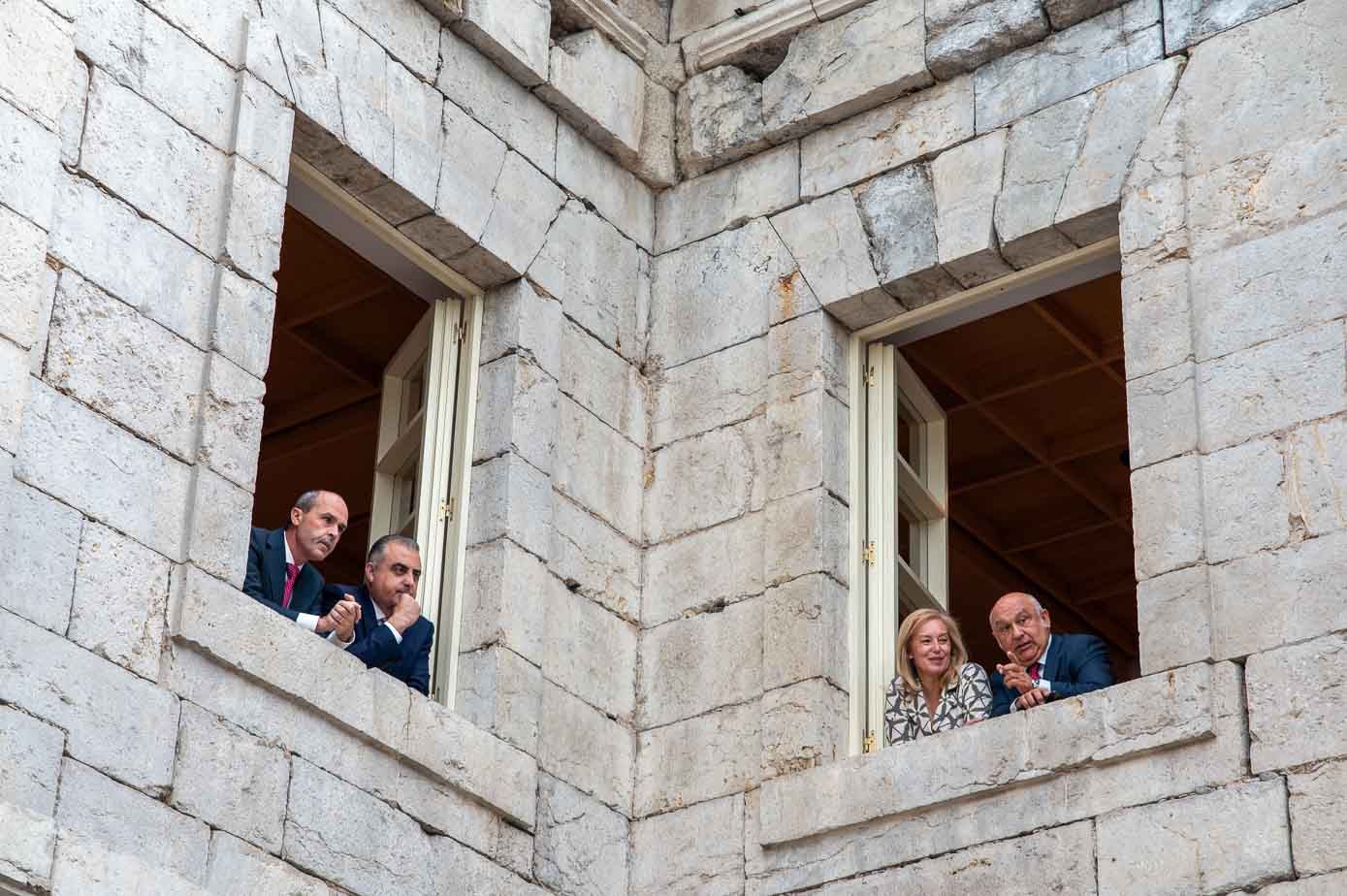 Desde las ventanas del Parlamento, Juan José Alonso, Roberto Media, María José González Revuelta y Miguel del Río observan a la gente que va llegando al acto. 