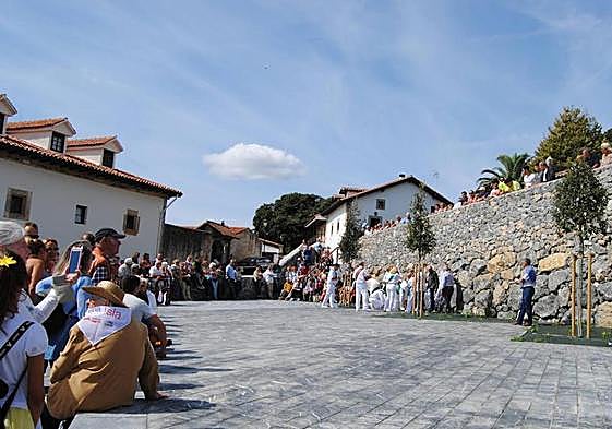 Varias personas se congregan en la plaza de Isla, en el municipio de Arnuero
