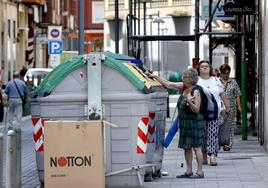 Una vecina recicla unos residuos plásticos en el contenedor, esta semana, en Torrelavega.