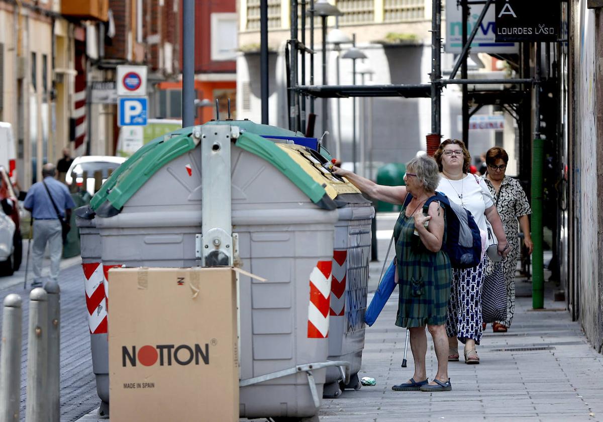 Una vecina recicla unos residuos plásticos en el contenedor, esta semana, en Torrelavega.