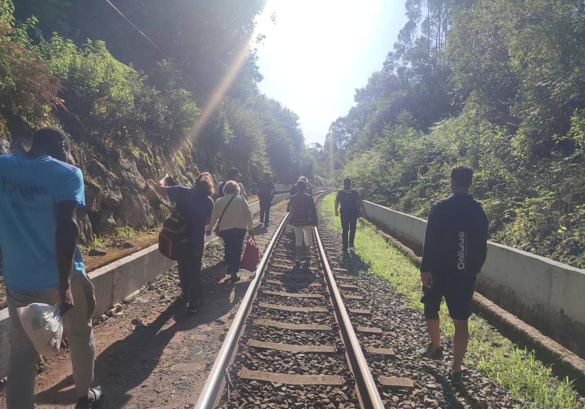 Los pasajeros del tren averiado se desplazan por la vía hasta Beranga acompañados de la Guardia Civil.