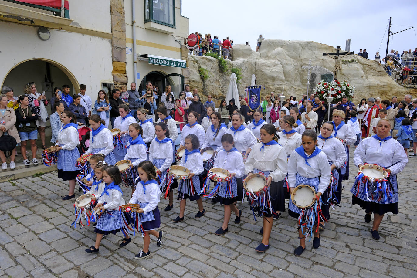 Las pandereteras en primer término escoltando al Cristo desde el puerto. 