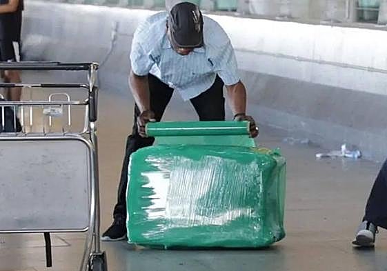 Un pasajero embalando su maleta antes de facturarla en el aeropuerto.