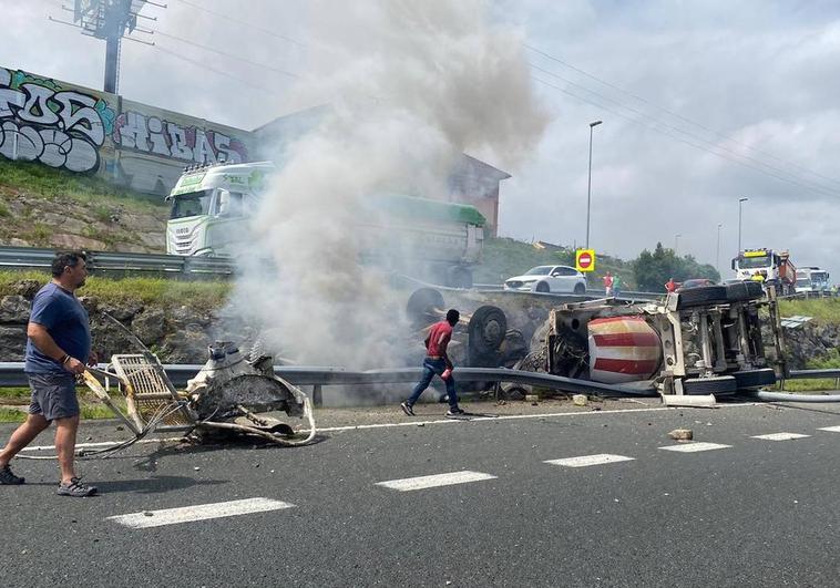 La cabina del camión hormigonera se incendió instantes después de volcar con el conductor atrapado dentro.