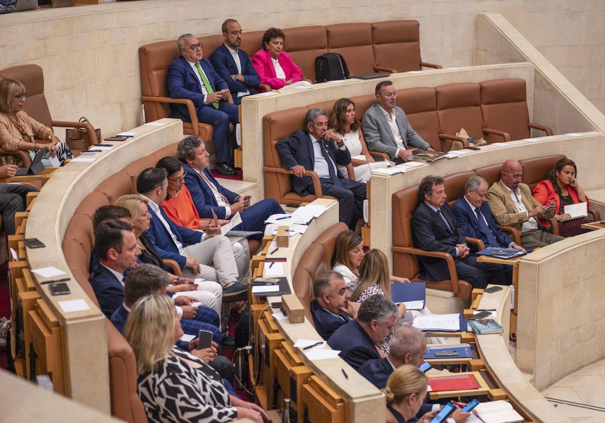 Los nuevos consejeros, en primera fila, con los diputados del PP detrás, ya sentados en sus escaños definitivos del hemiciclo.