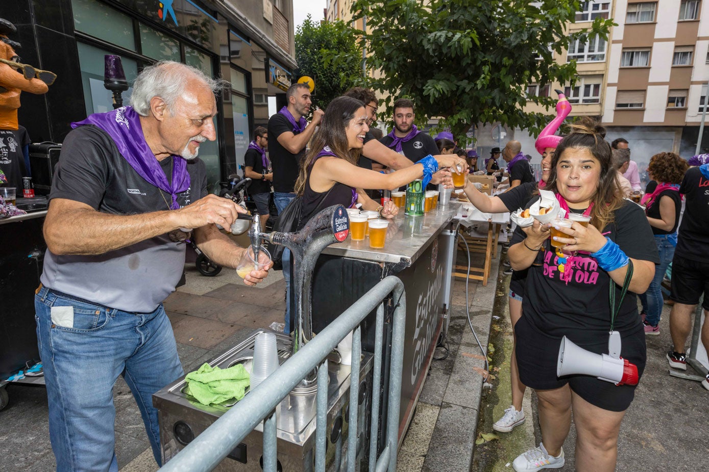 Los miembros de la peña repartiendo bebidas.