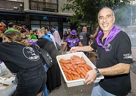 Un miembro de la Peña Los Chatos muestra el menú de la jornada. Lo recaudado irá destinado al Banco de Alimentos