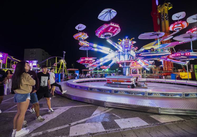 Imagen principal - 1. Jóvenes esperando su turno en una de las atracciones. | 2. Una pareja disfrutando de los coches de choque. | 3. Una de las atracciones acuáticas.