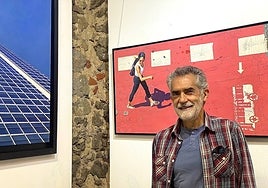 El artista Carlos Marijuan posando frente a sus cuadros