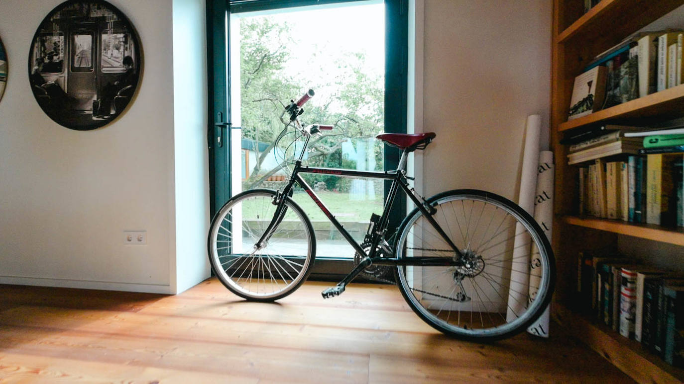 Bicicleta de Miguel, apoyada contra una de las puertas que da a la piscina.