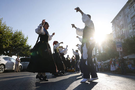 Unas parejas bailan una jota montañesa en pleno desfile del pasacalles cántabro