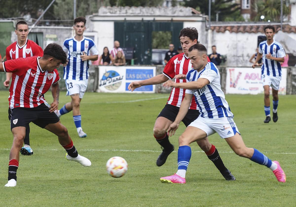 Saúl, de la Gimnástica, trata de avanzar con el balón ante varios rivales del Basconia.