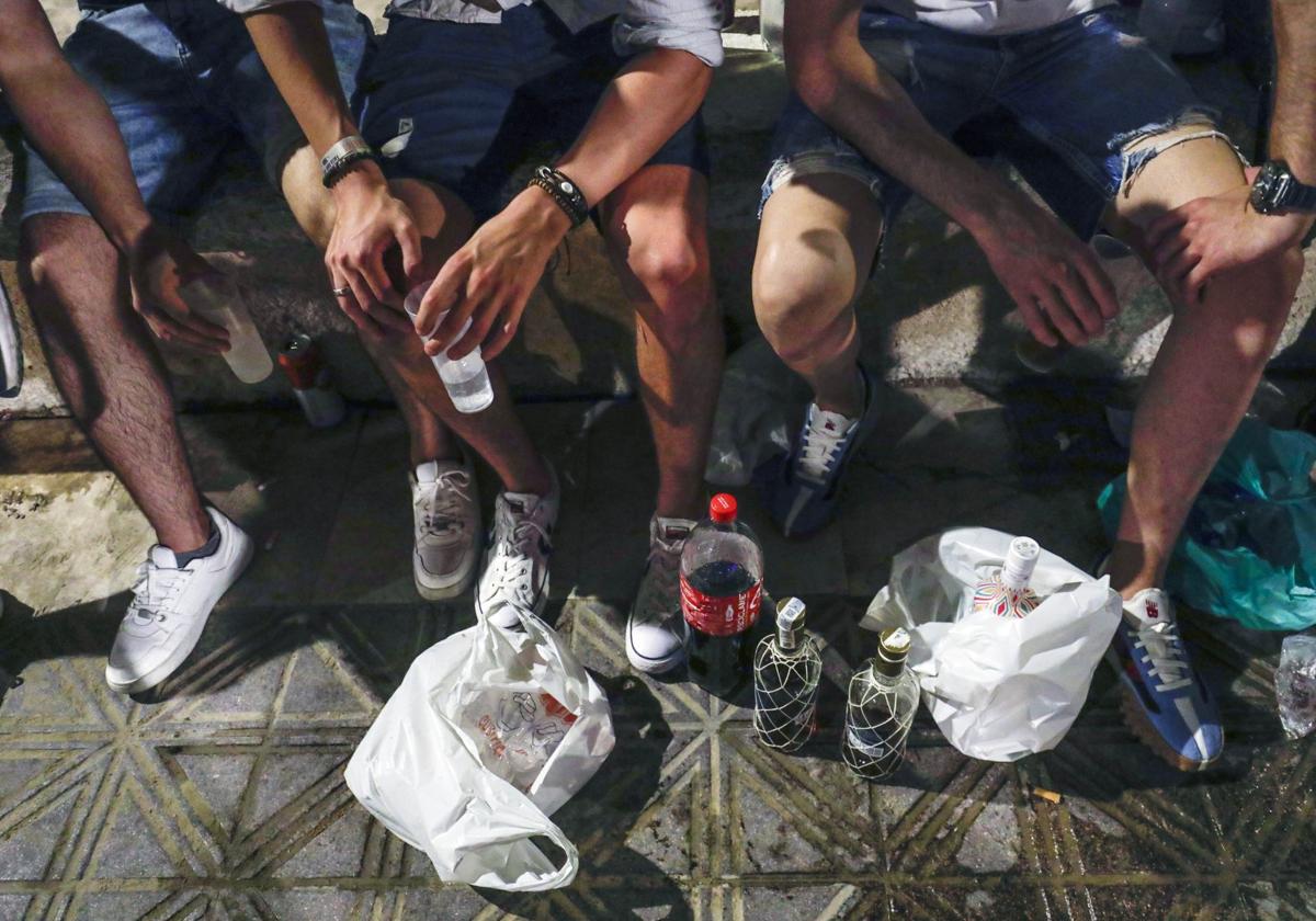 Un grupo de jóvenes hace botellón en la calle.