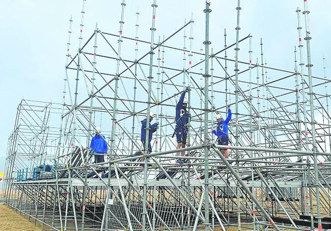 Los operarios trabajando ayer en la construcción del escenario.