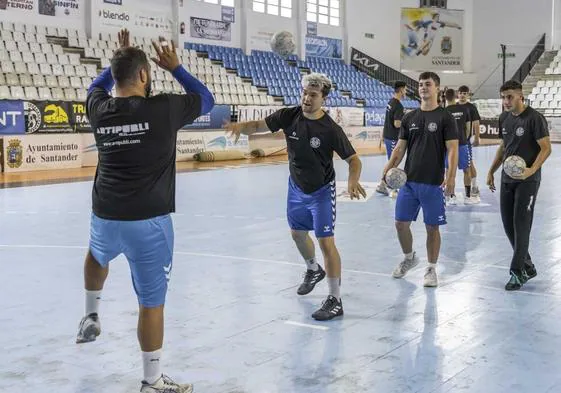 Los jugadores del Blendio Sinfín disparan a puerta durante el calentamiento previo a un entrenamiento en La Albericia.