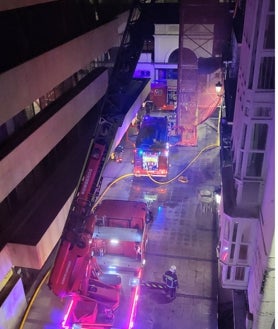 Imagen secundaria 2 - Arriba, nube de humo sobre la vivienda. Abajo, dispositivo desplegado en pleno centro de la ciudad y de los bomberos accediendo a la vivienda en grúa.