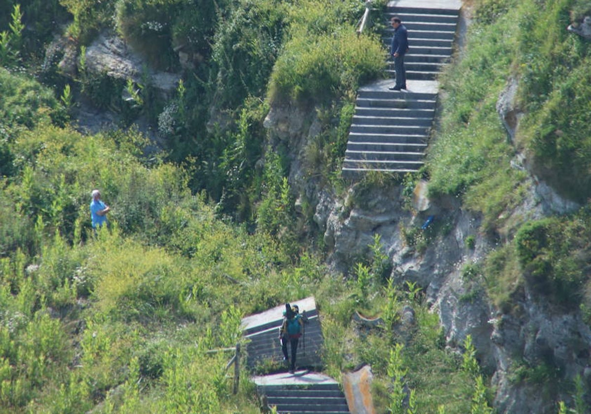 Tres personas intentan salvar el desprendimiento de las escaleras de acceso a la playa.