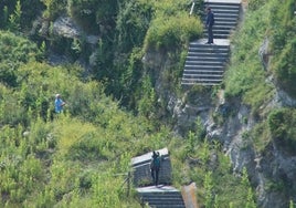 Tres personas intentan salvar el desprendimiento de las escaleras de acceso a la playa.