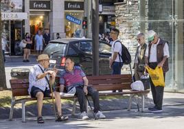 Varios jubilados charlan sentados en un banco, esta semana, en la plaza del Ayuntamiento de Santander.