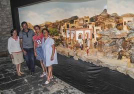 Mercedes Aguirre, Pedro Prieto, Isabel Expósito y María Ángeles Campo, junto al belén expuesto en el pórtico de la iglesia de Ajo.