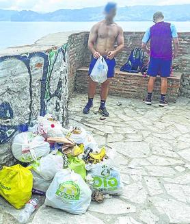 Imagen secundaria 2 - Bañistas dándose un chapuzón, aunque esté prohibido. Las bolsas de basura se acumulan en la plataforma. 