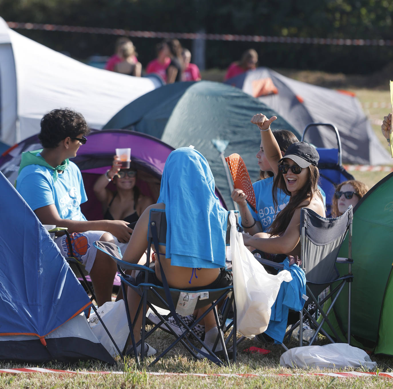 Chavales saludan mientras charlan al sol, en uno de los muchos campamentos instalados en la zona. 