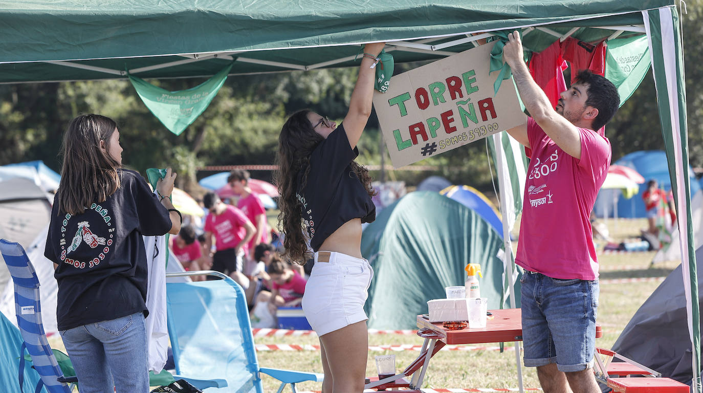 Peñistas bautizan su campamento con un cartel, este jueves, en una de las carpas instaladas en estos terrenos verdes.