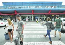 Año 2015. Pasajeros ante los carteles nuevos en la terminal tras confirmarse el cambio de nombre del aeropuerto.