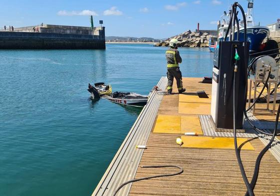 Restos de la moto de agua flotando en el pantalán de la gasolinera portuaria tras la explosión.