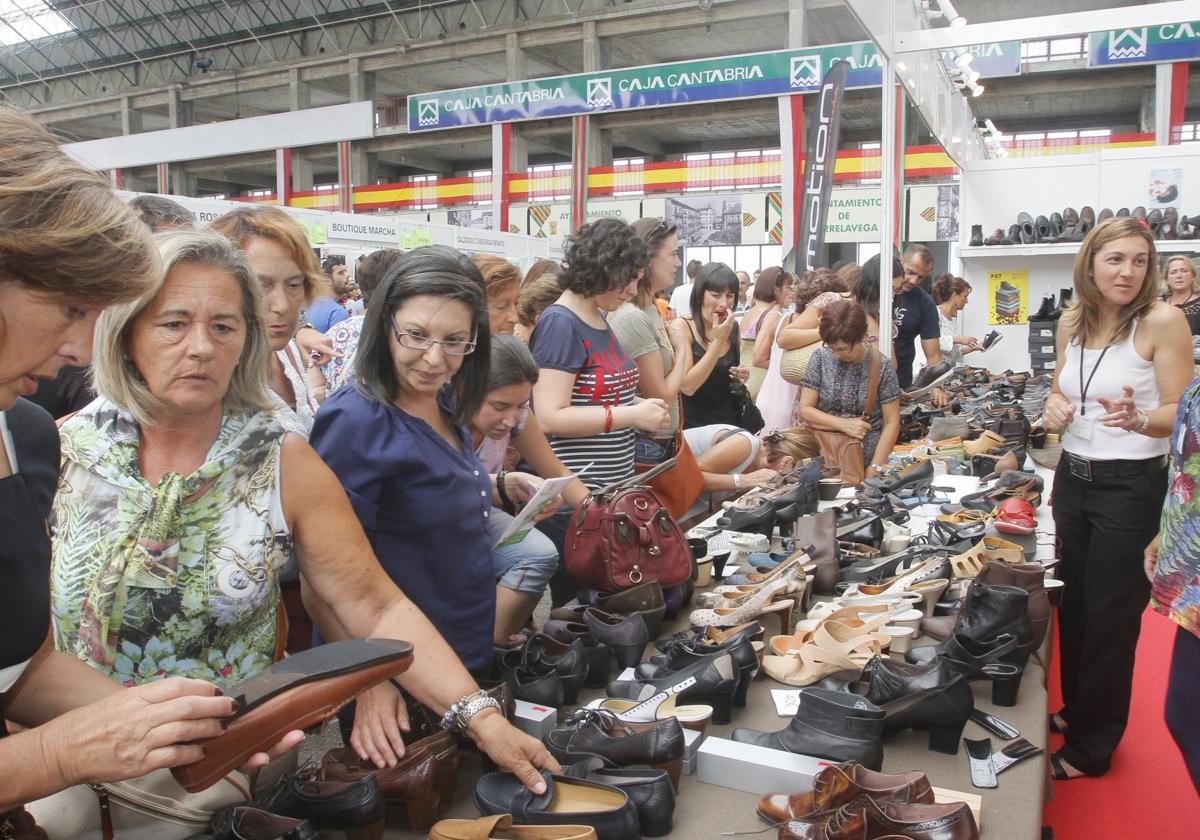 Numerosos clientes ojean zapatos de oferta en uno de los puestos de la Feria del Stock de Torrelavega.