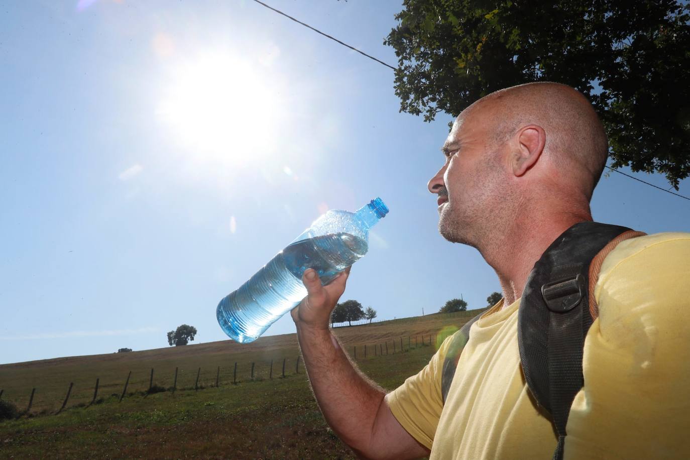 Un hombre, que trabaja desbrozando, se refresca en Soba.