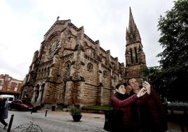 Una pareja de turistas franceses se hace un selfi junto a la iglesia de La Asunción.