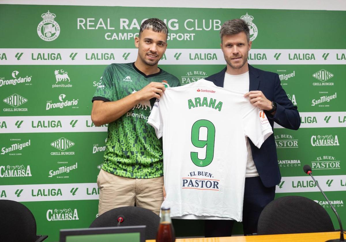 Juan Carlos Arana sujeta la que será su nueva camiseta junto a Mikel Martija