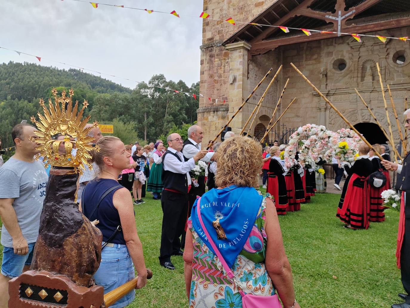 Hombres y mujeres preparan el camino por el que se recibe a la Virgen de Valencia con honores y flores