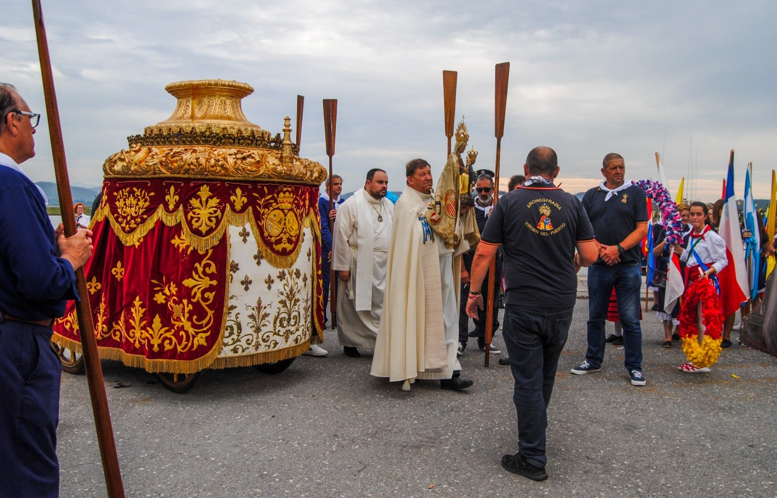 El párroco de Santoña, Alberto García, procede a llevar a la virgen al pesquero para embarcarla.