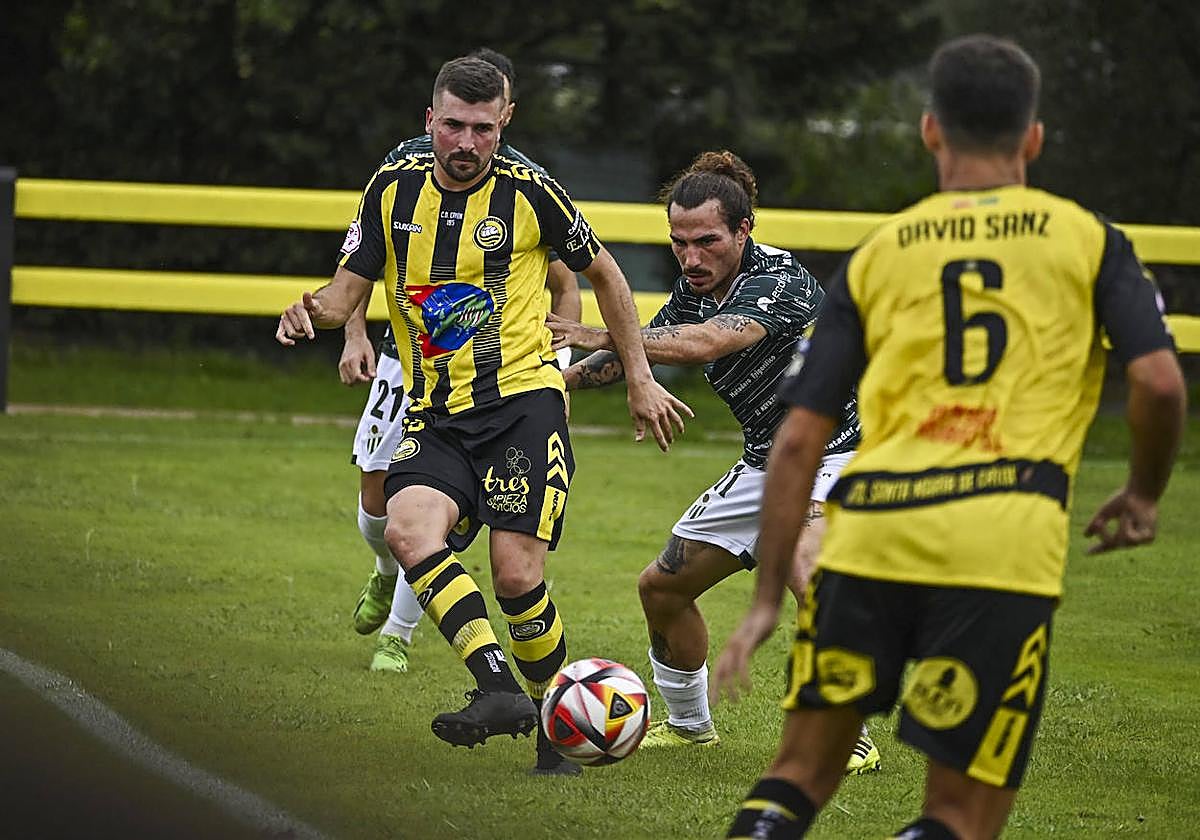 Montiel retrasa el balón ante la presión de un rival.