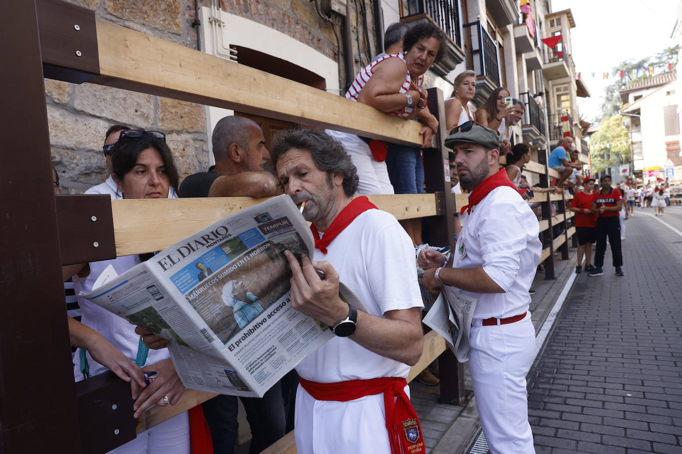 Uno de los corredores repasa la crónica del encierro del día anterior en el El Diario Montañés. 