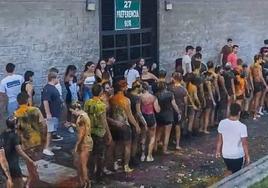 Los estudiantes de primer curso, en fila india, empapados y manchados, a las órdenes de los veteranos, el pasado miércoles, en El Sardinero.