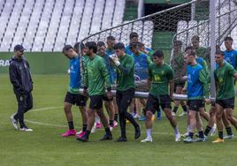 Los jugadores del Racing trasladan una de las porterías de La Albericia en un entrenamiento de esta semana, donde la lluvia les acompañó.