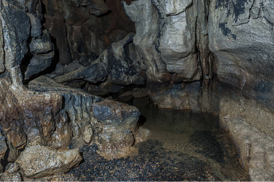 La zona Basal está atravesada por el río que ha formado la cavidad, un lugar de muy difícil acceso. Su singularidad es su intenso color negro debido al depósito de óxido de manganeso