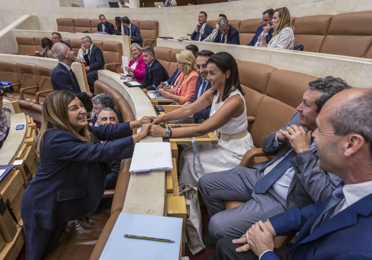 La presidenta María Saénz de Buruaga saluda a la alcaldesa de Santander, Gema Igual, al llegar a la bancada del PP antes del inicio del Pleno del Parlamento de ayer.