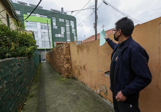 Un vecino señala la vivienda de la calle José Rioja de Santander donde se produjeron los hechos.