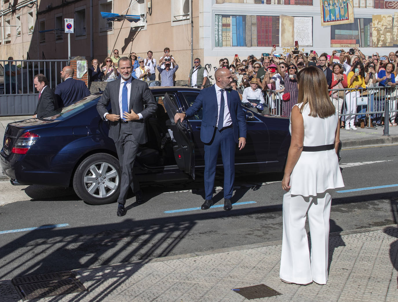 La presidenta del Gobierno de Cantabria recibe al monarca nada más llegar al Paraninfo, mientras decenas de ciudadanos grababan la escena con sus móviles 