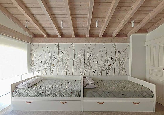 En el cuarto de juegos colocaron dos camas-nido y en la pared, un mural de papel pintado, con motivos de árboles y pájaros