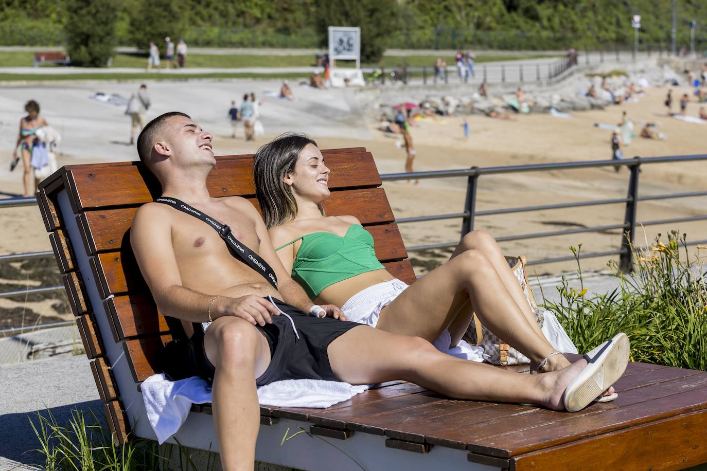 Una pareja toma el sol en una de las tumbonas de la zona del dique de Gamazo, en Santander.