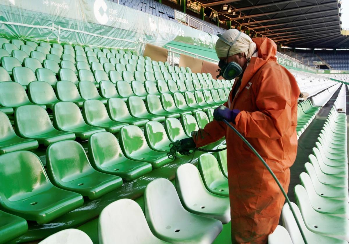 Un operario realiza el pintado de los asientos de El Sardinero.