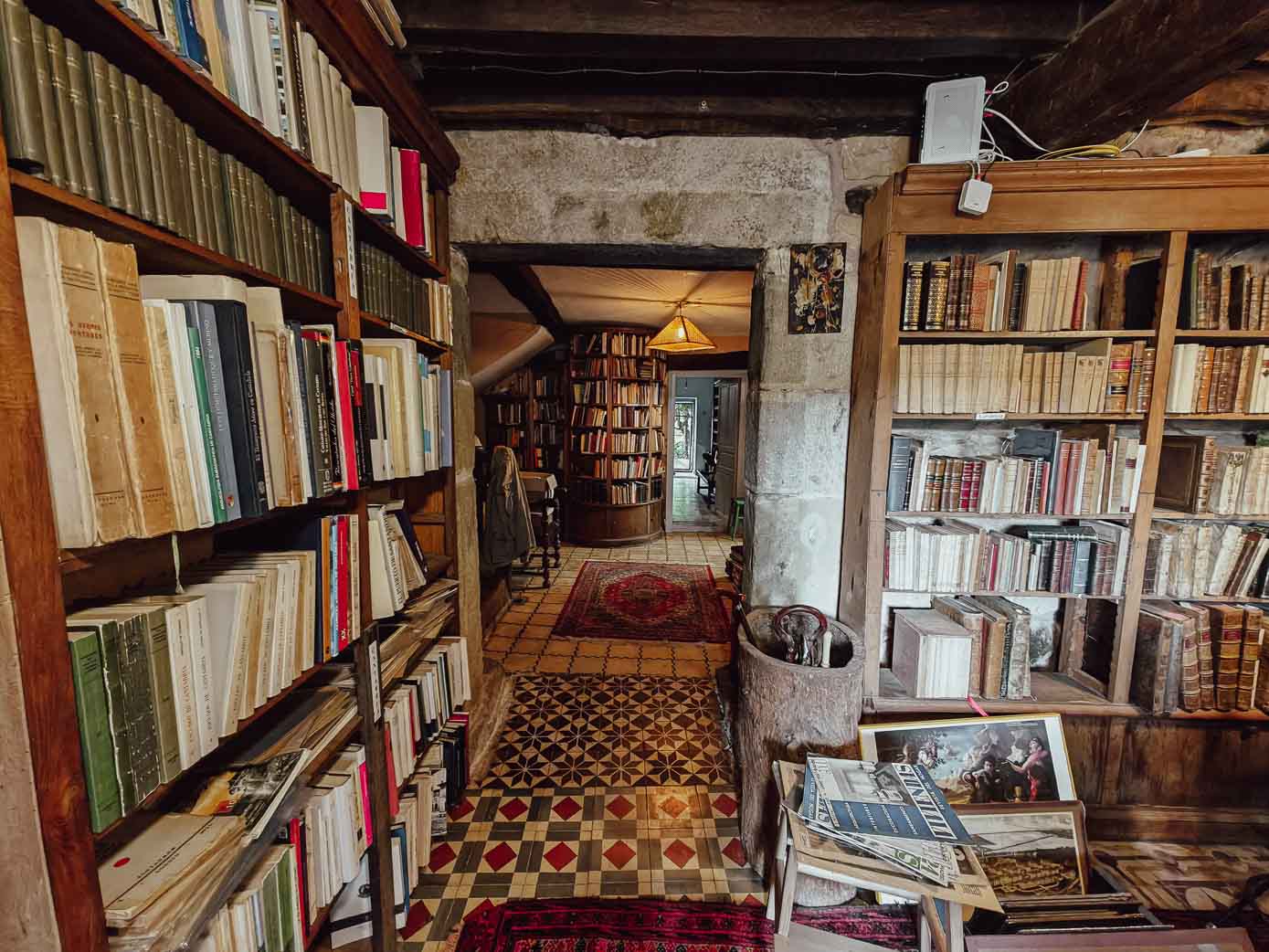 Entrada a la librería de Lloreda de Cayón repleta de libros y con suelos de azulejo hidráulico.