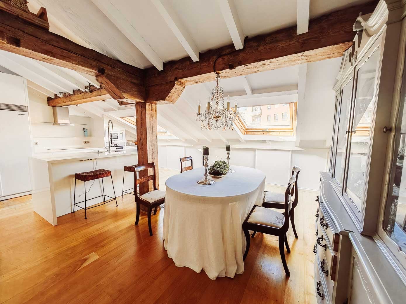 La zona de la cocina se instaló a la izquierda, mientras que el comedor se colocó a la derecha, a la entrada de la estancia, con una lámpara de cristal de lágrimas sobre la mesa.