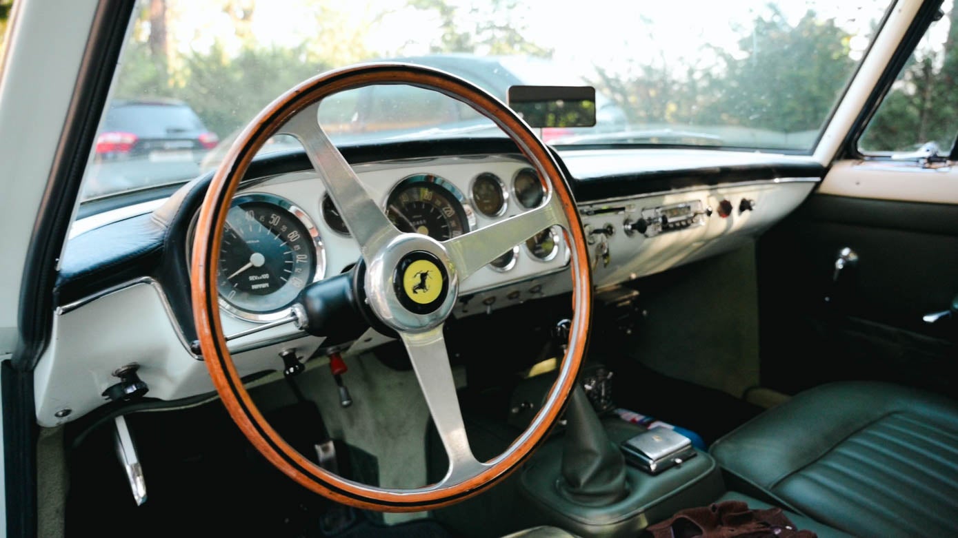 Detalle del interior del Ferrari, con su volante de madera.